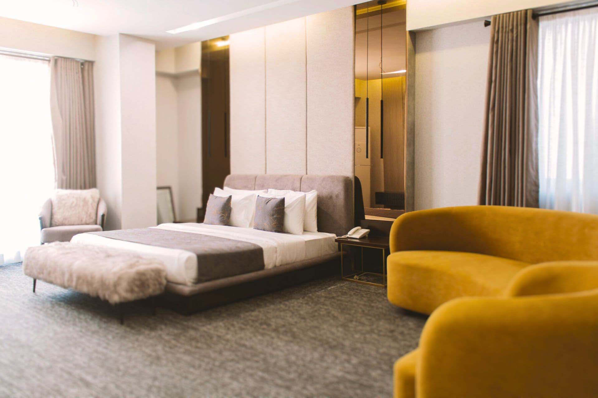 Couple relaxing on a cozy hotel bed at LEORK Hotels Rawalpindi, watching TV and enjoying a romantic stay