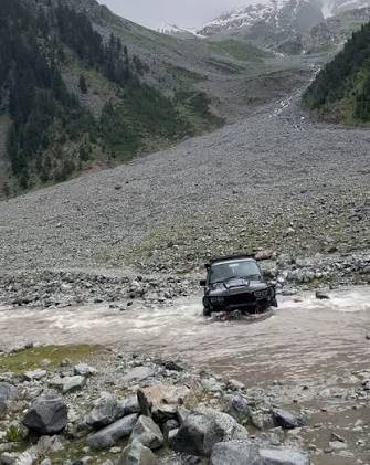 4x4 jeep crossing a stream on the Mahodand Lake track near Kalam