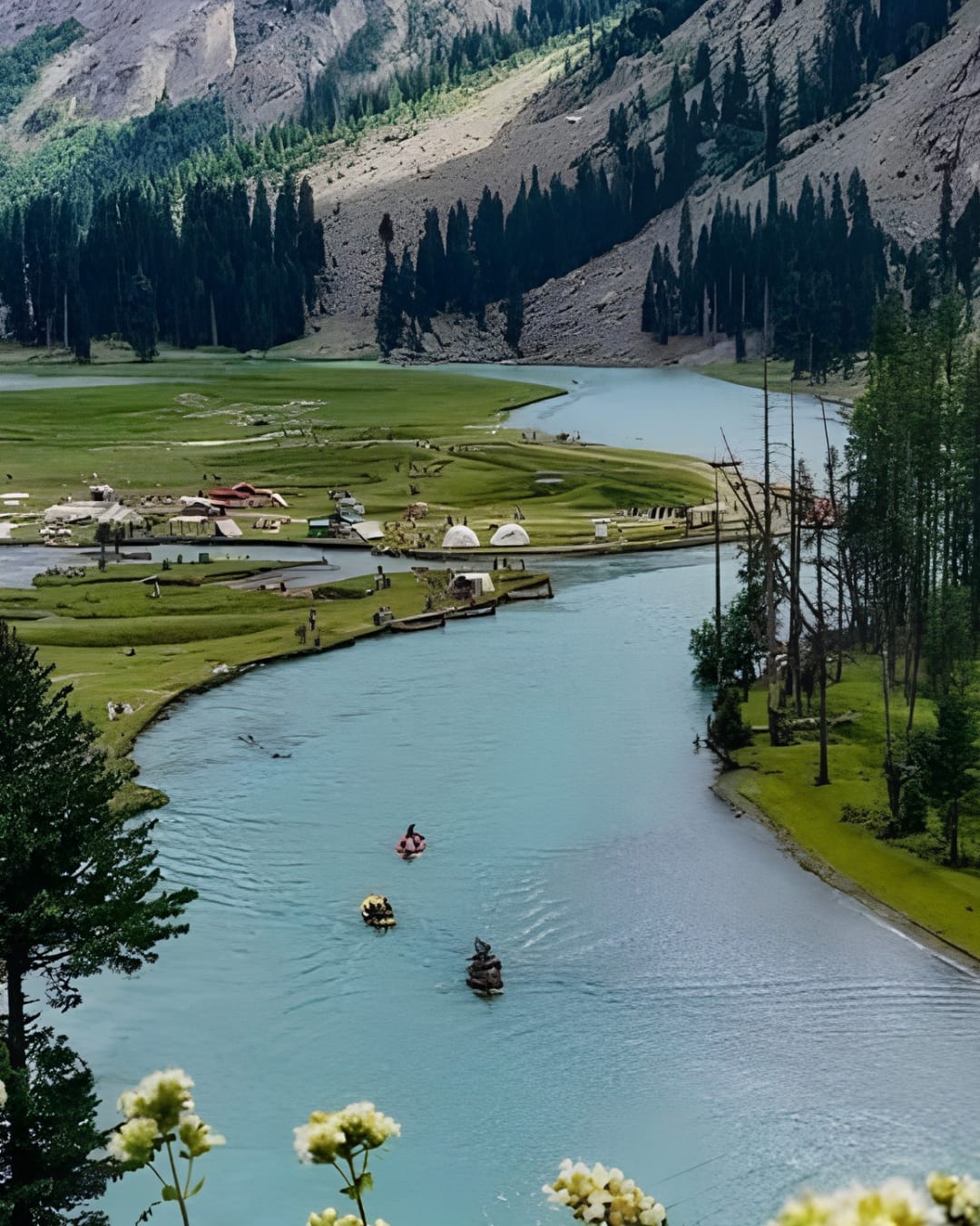 Mahodand Lake near Kalam Valley with green meadows, a winding river and camping pods.