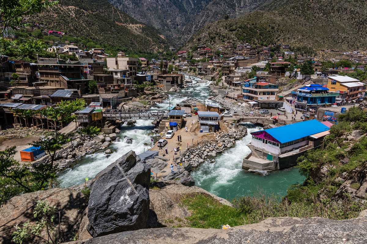 The Swat River rushing between the buildings and bridges of Bahrain town