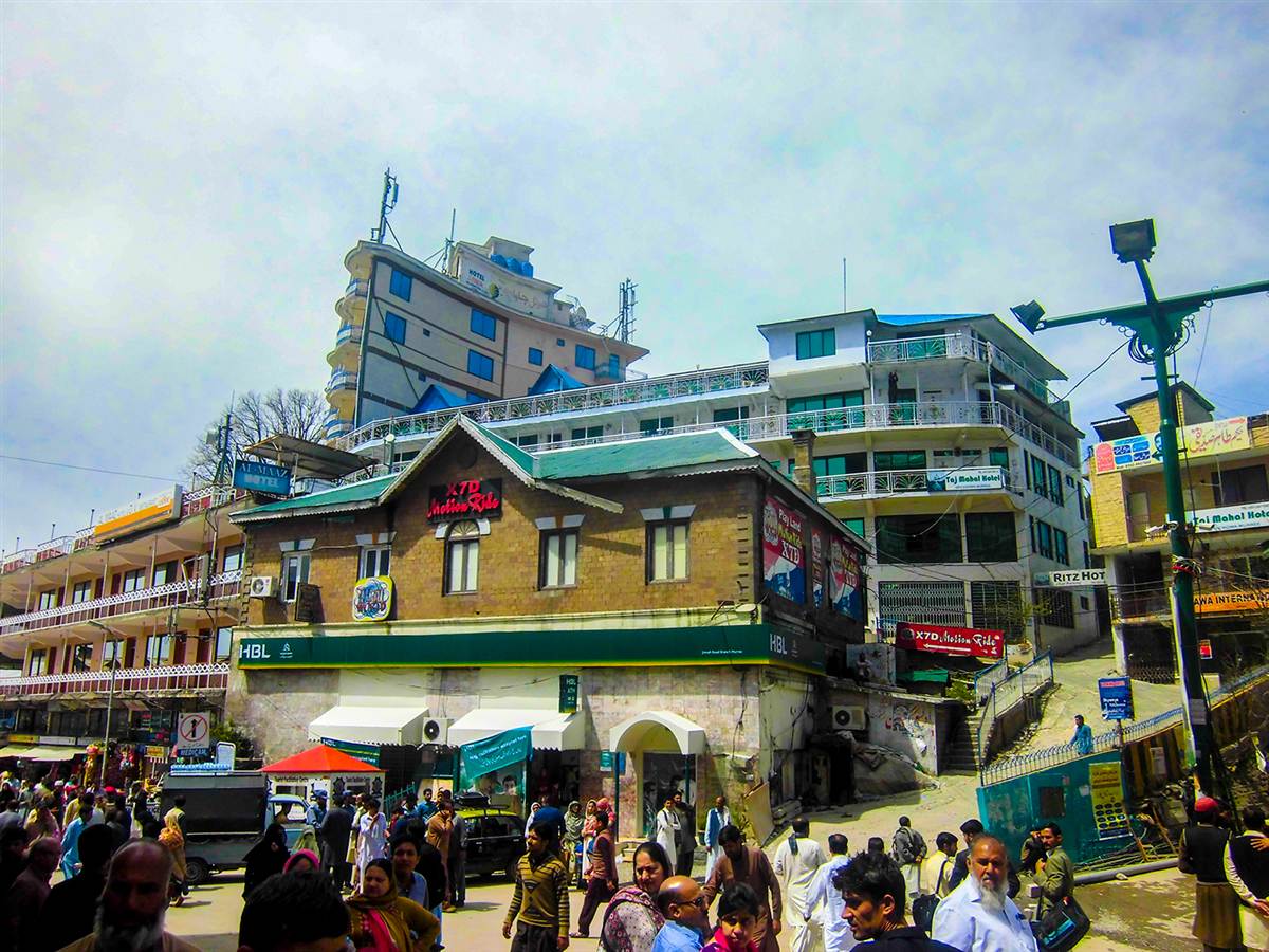 Crowded Mall Road in Murree on a clear day, with hotels stacked up the hillside