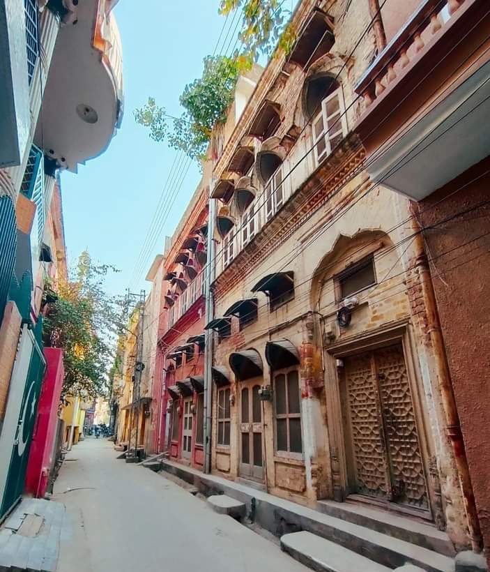 Old haveli facades and carved wooden doors in a quiet lane of Rawalpindi's old city.