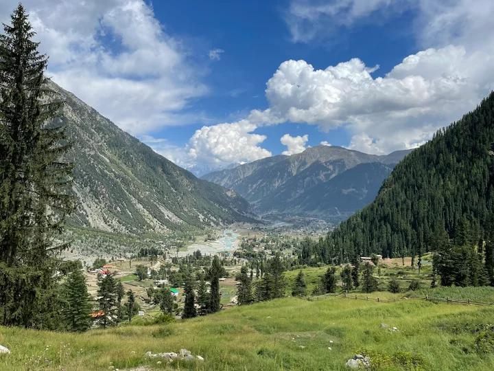 Green Utror valley in summer with villages scattered along the river below forested ridges