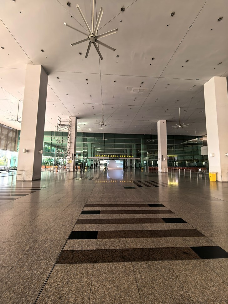 Islamabad International Airport terminal at dusk with the car park in front.