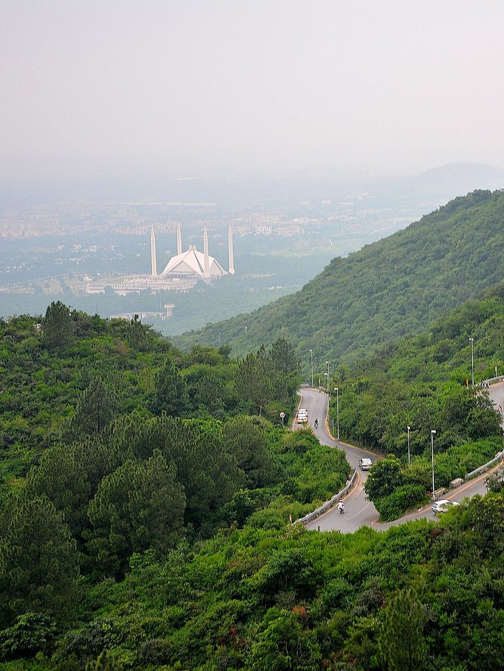 Faisal Mosque in Islamabad seen through haze from the winding road up the Margalla Hills.