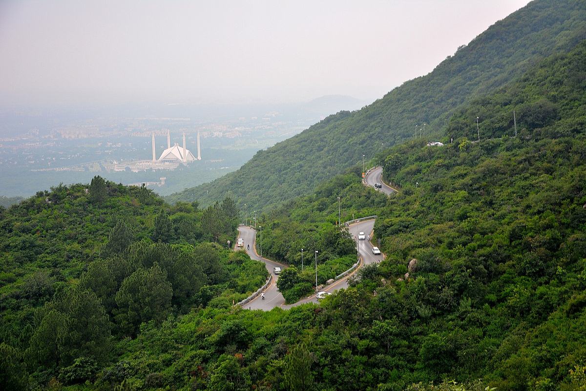 Faisal Mosque in Islamabad seen through haze from the winding road up the Margalla Hills.