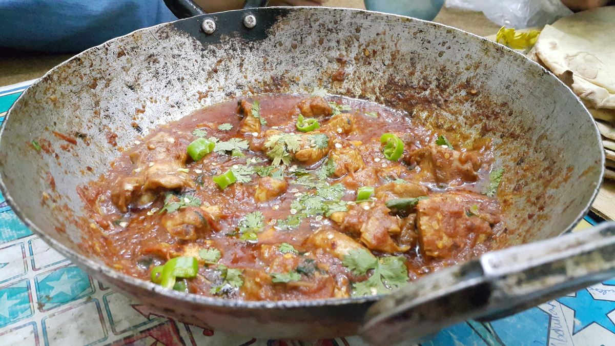 Chicken karahi in a wok served with naan