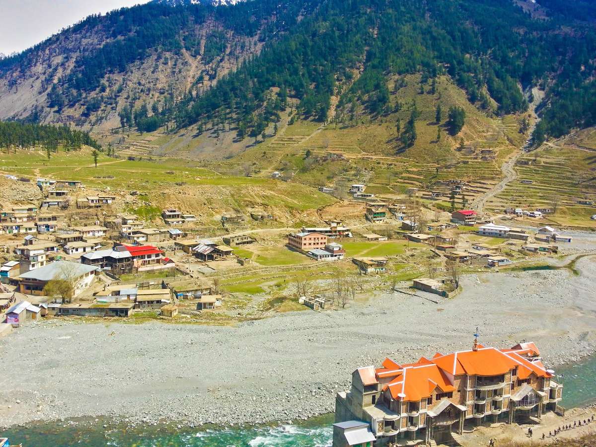 Kalam town from above with an orange-roofed hotel beside the Swat River
