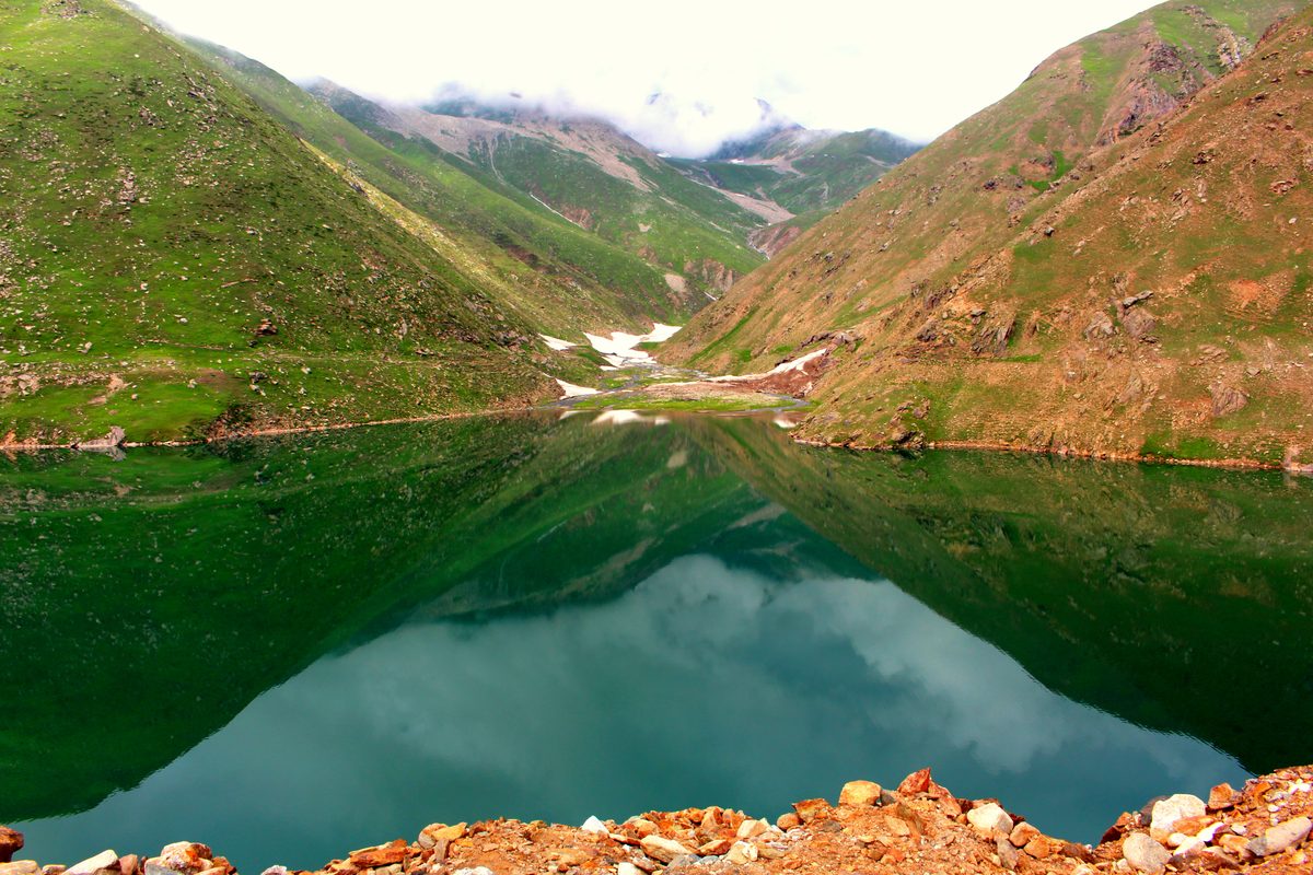 Lulusar Lake reflecting green slopes in the Kaghan Valley