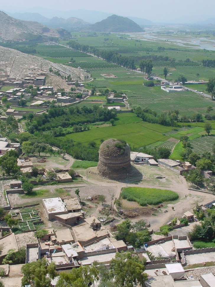 Aerial view of Shingardar Stupa beside the main road in Swat with green fields and the Swat River.