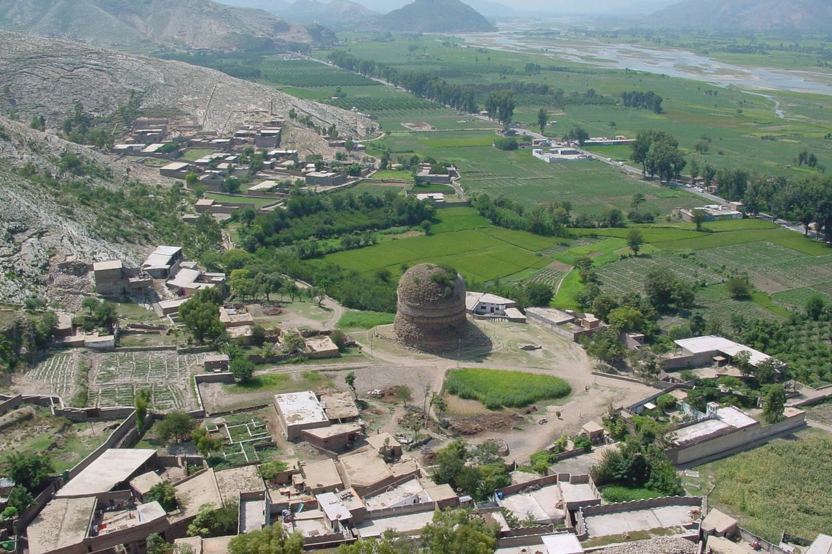 Aerial view of Shingardar Stupa beside the main road in Swat with green fields and the Swat River.