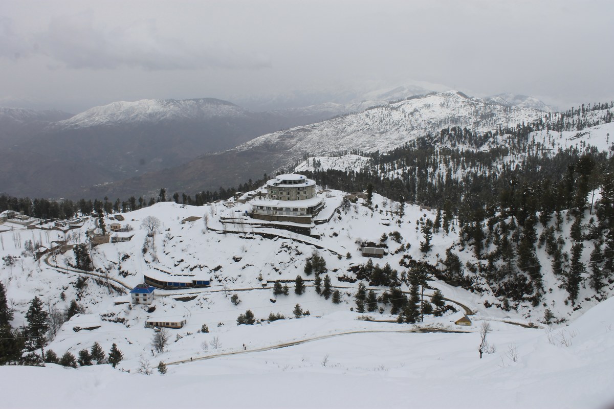 Wide winter view of the Malam Jabba resort hill with snow and winding roads