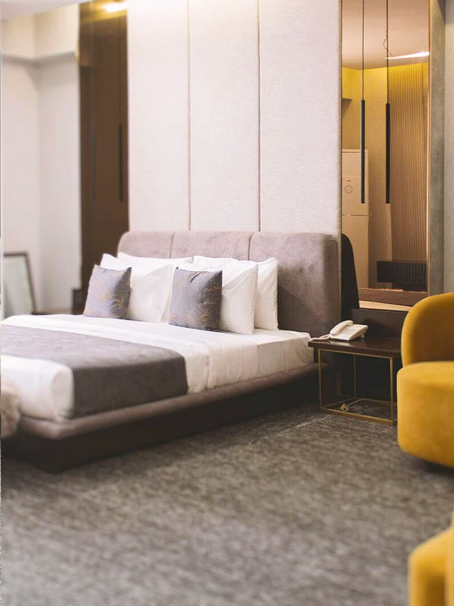 Deluxe King Room with bed, headboard, and side mirrors at LEORK Hotels Rawalpindi Islamabad