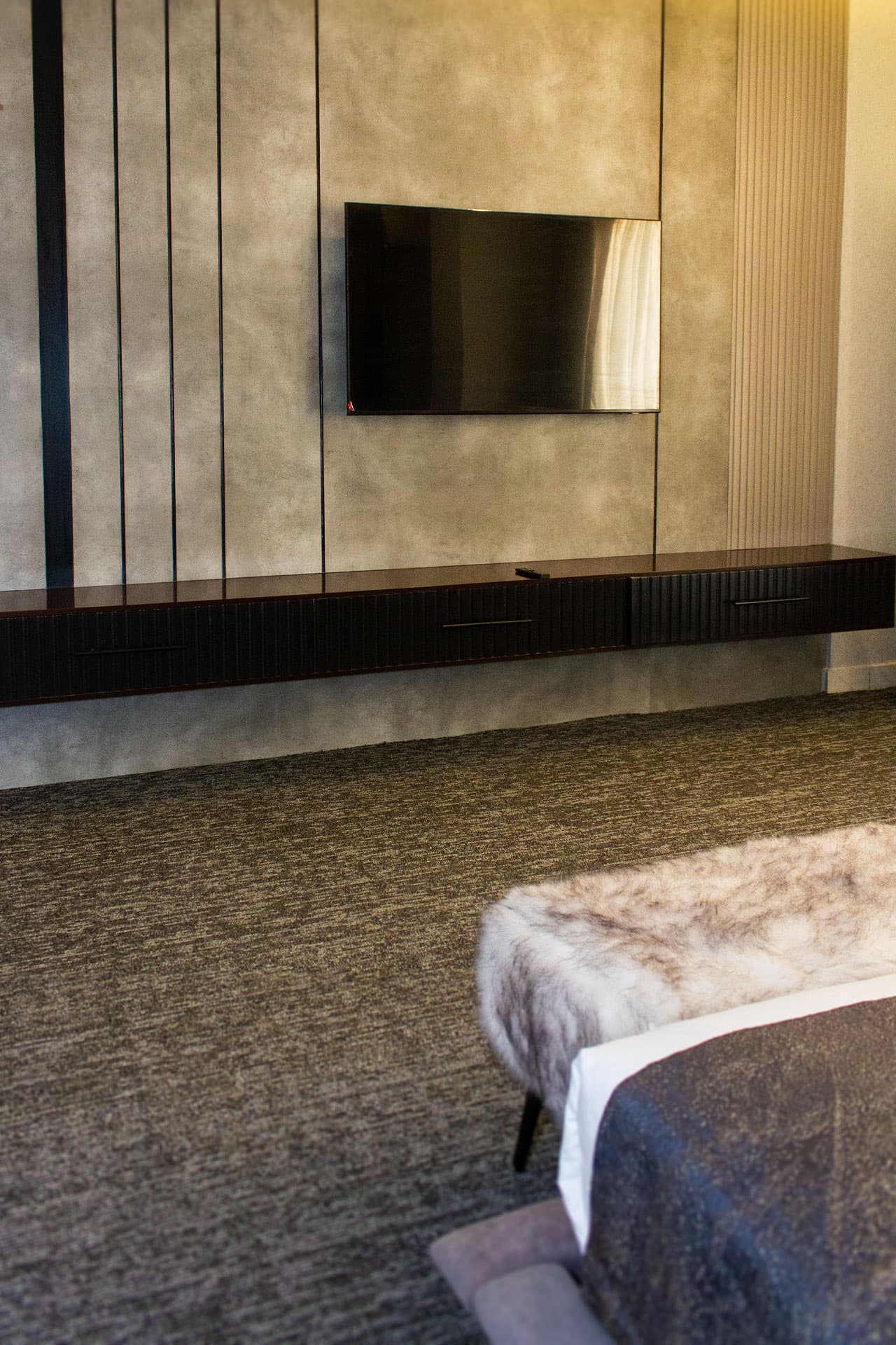 Deluxe King Room mobile view with TV, media wall, bed, and carpet at LEORK Hotels Rawalpindi Islamabad