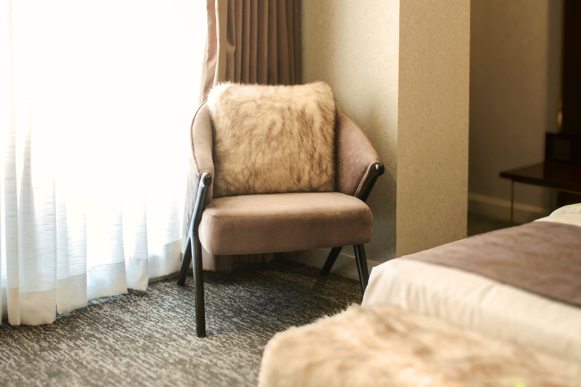 Deluxe King Room with comfy chair, cushion, window, and curtains at LEORK Hotels Rawalpindi Islamabad