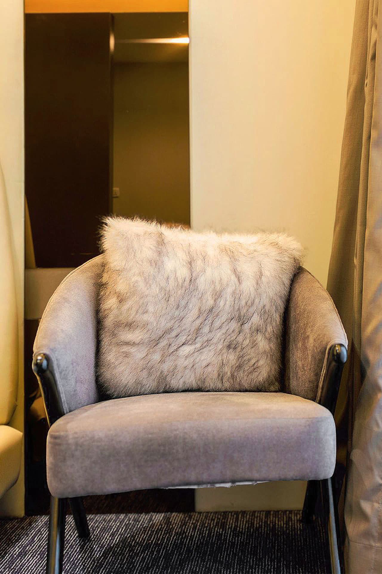 Family Room mobile close-up of chair with fur cushion, mirror, carpet, and modern design at LEORK Hotels Rawalpindi Islamabad