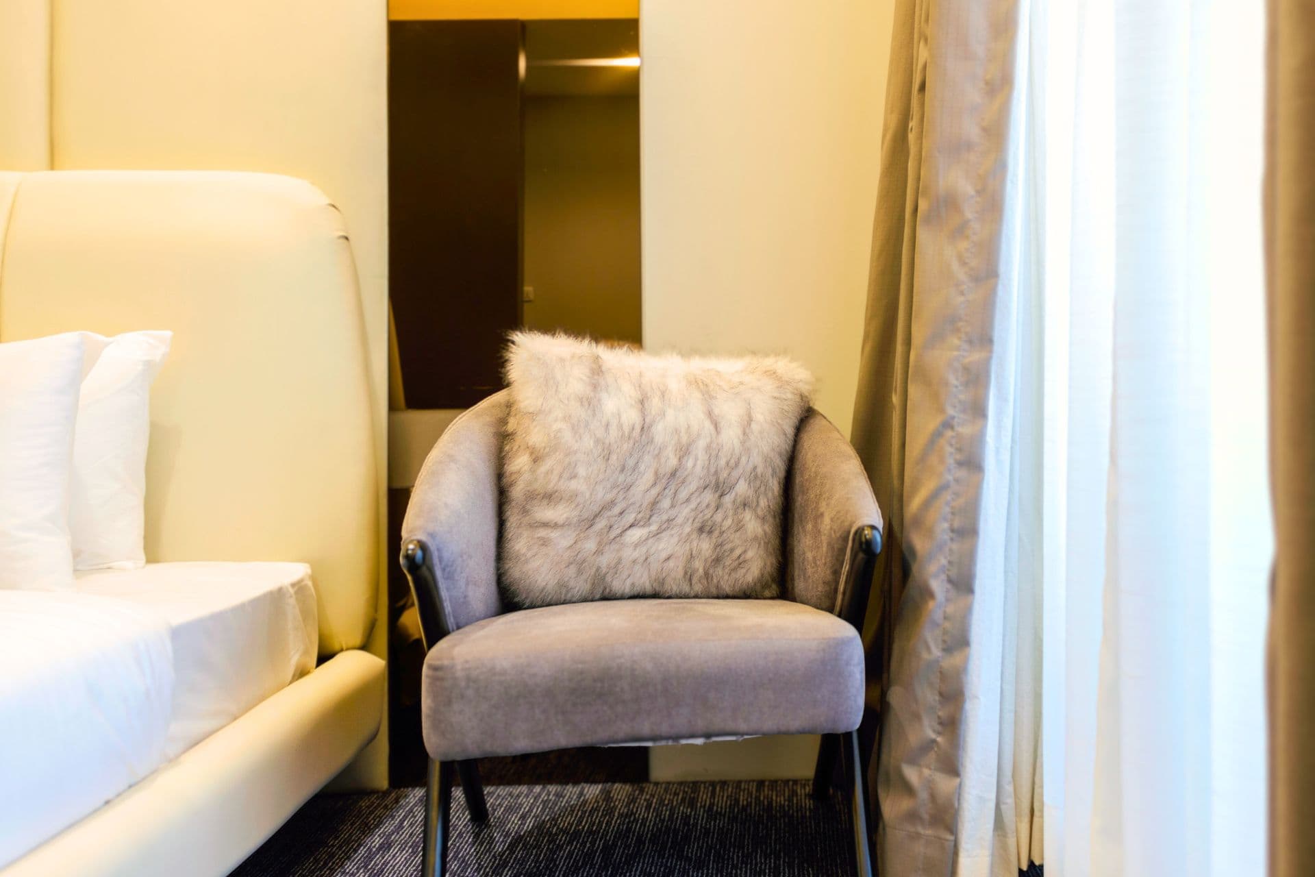 Family Room close-up of chair with fur cushion, mirror, carpet, and modern design at LEORK Hotels Rawalpindi Islamabad