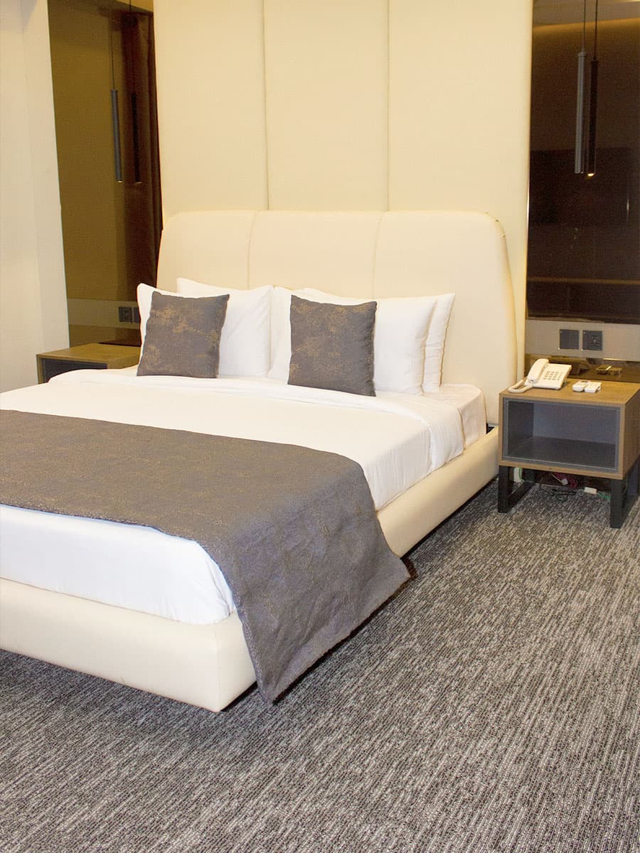 King Room bed with headboard, side tables, and mirrors at LEORK Hotels Rawalpindi Islamabad