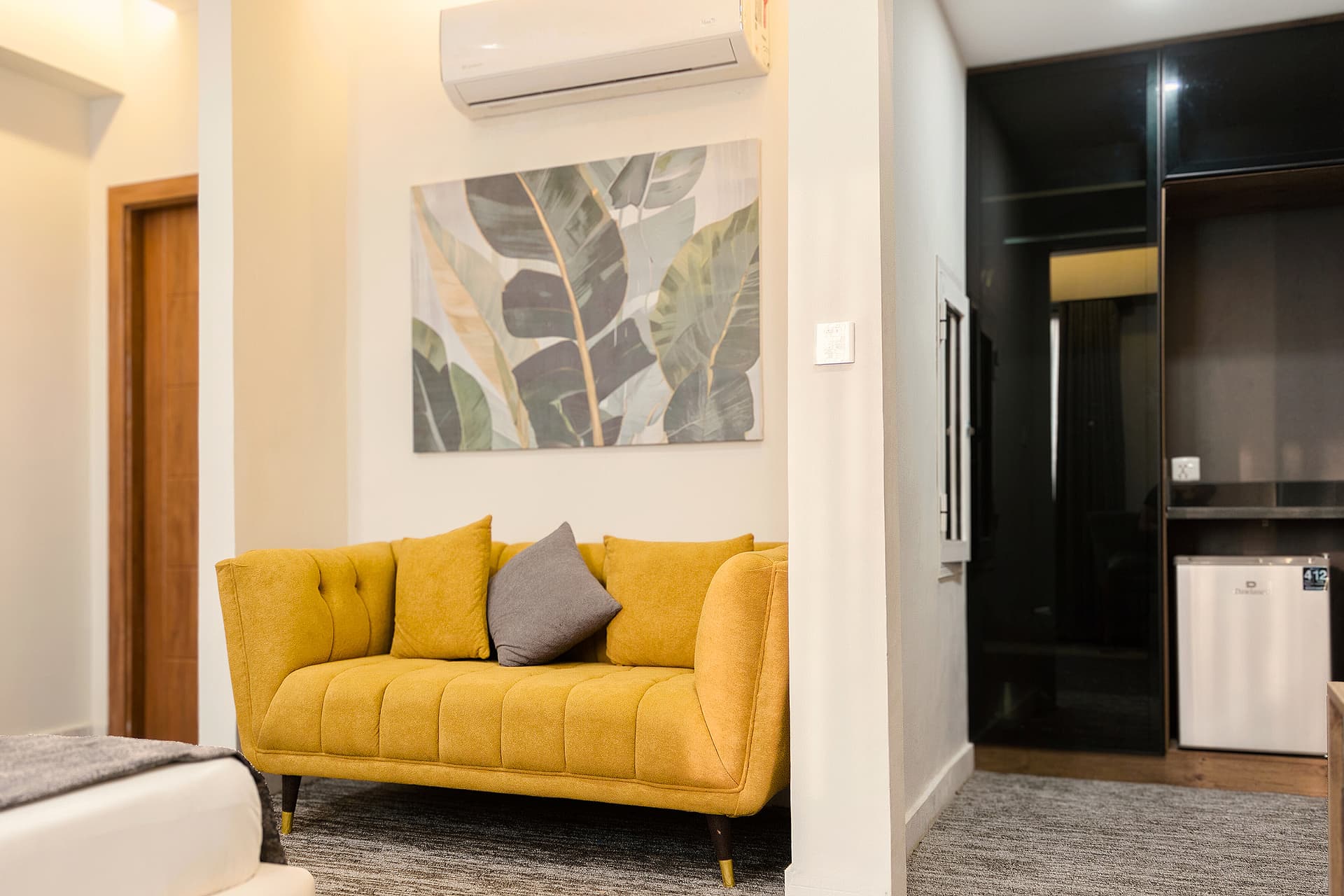 King Room view with sofa, fridge, wardrobe, painting, bathroom, and AC at LEORK Hotels Rawalpindi Islamabad