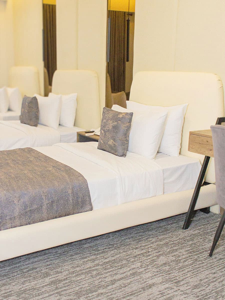 Triple Room with three beds, headboards, side tables, and mirrors at LEORK Hotels Rawalpindi Islamabad