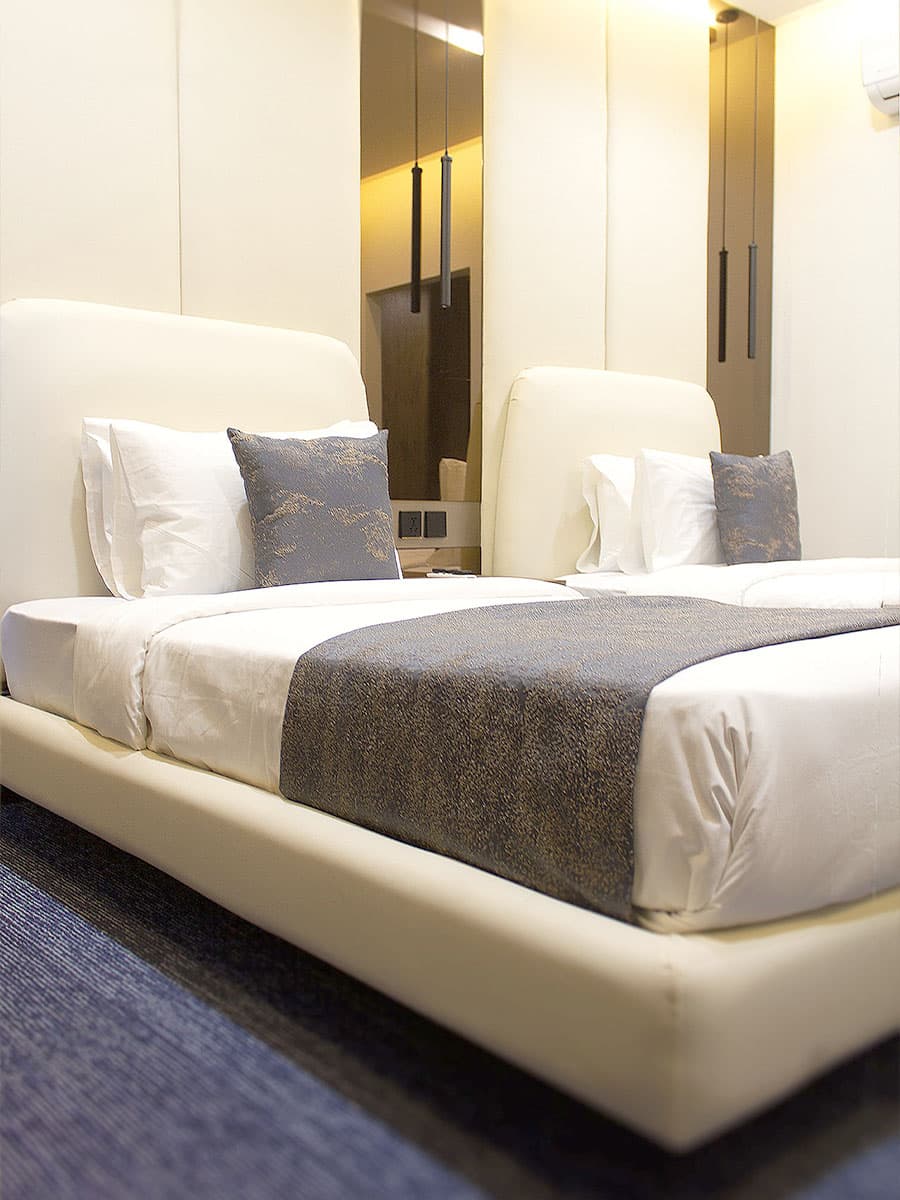 Twin Room with two beds, headboards, side tables, and mirrors at LEORK Hotels Rawalpindi Islamabad