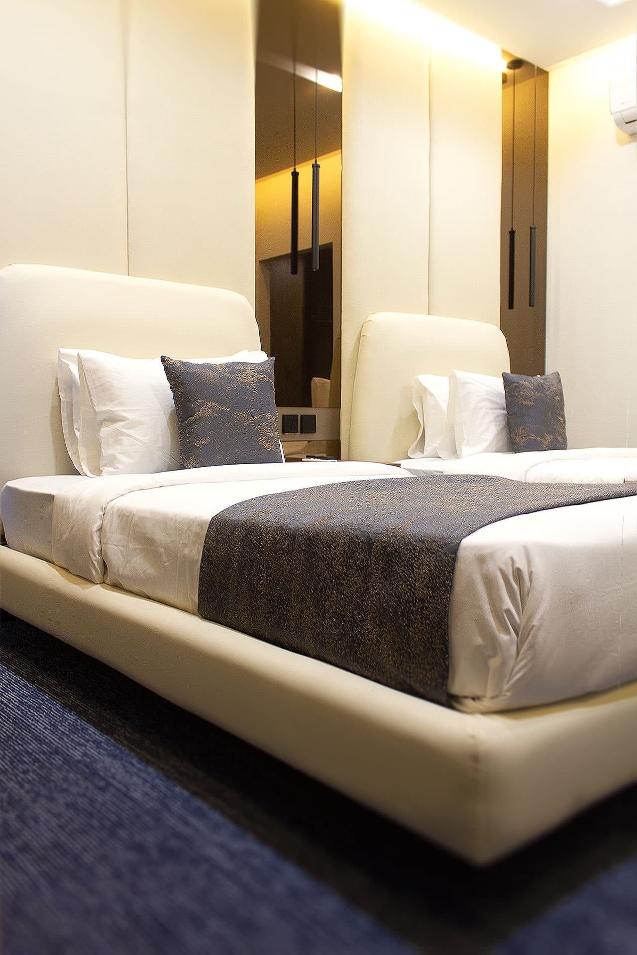 Twin Room mobile view with queen and single bed, mirror, headboard, window, curtains, and carpet at LEORK Hotels Rawalpindi Islamabad