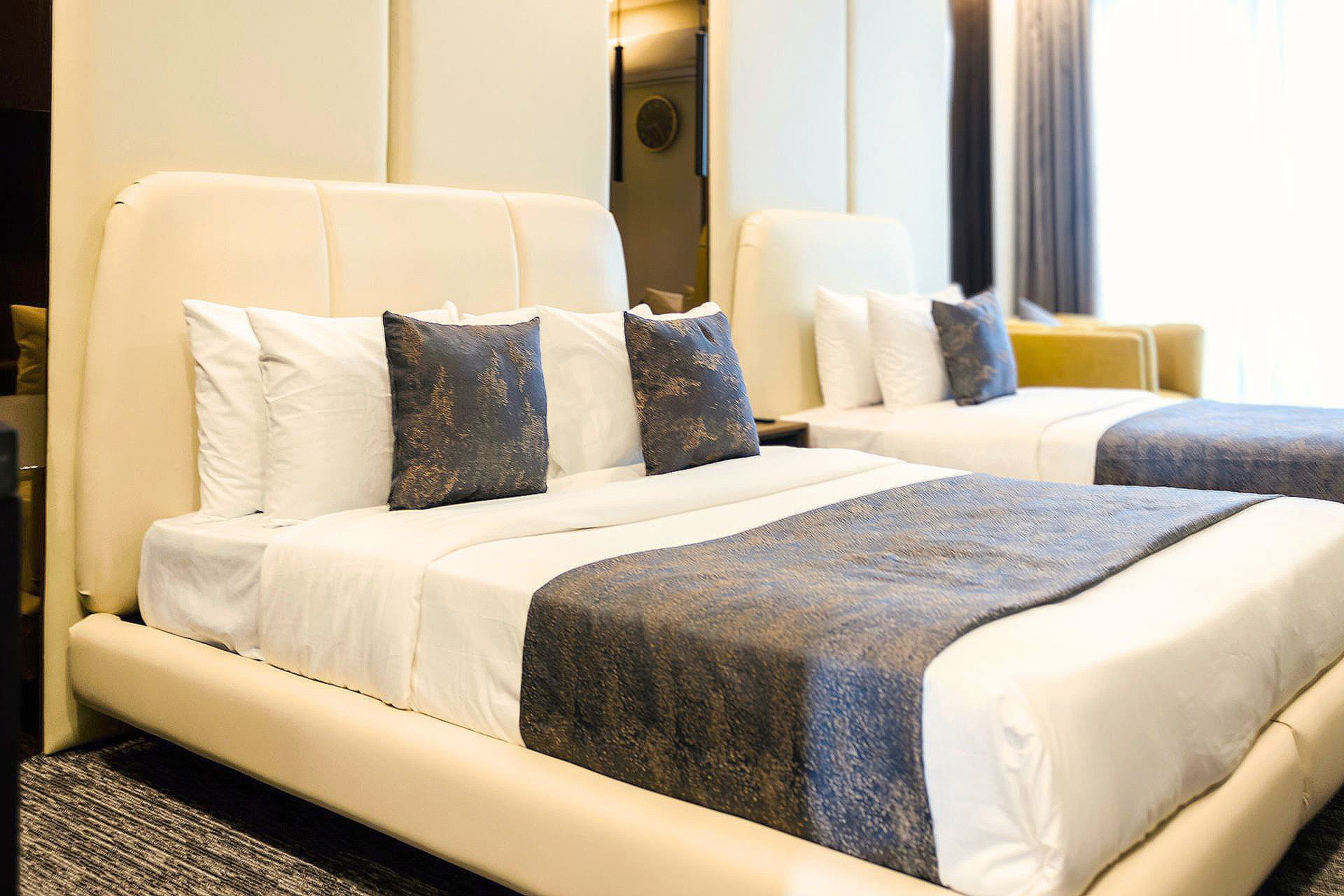 Twin Room full view with queen and single bed, mirror, headboard, window, curtains, and carpet at LEORK Hotels Rawalpindi Islamabad