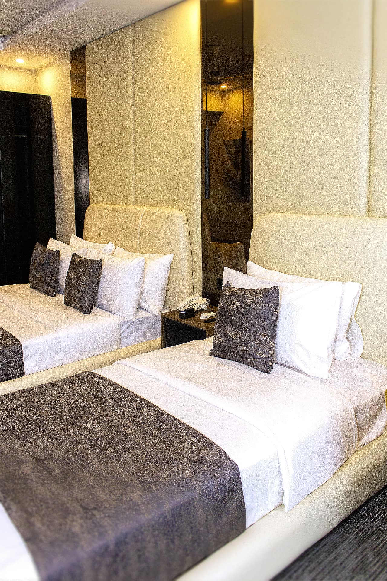 Twin Room mobile view with two single beds, headboards, pillows, mirror, lights, and carpet at LEORK Hotels Rawalpindi Islamabad