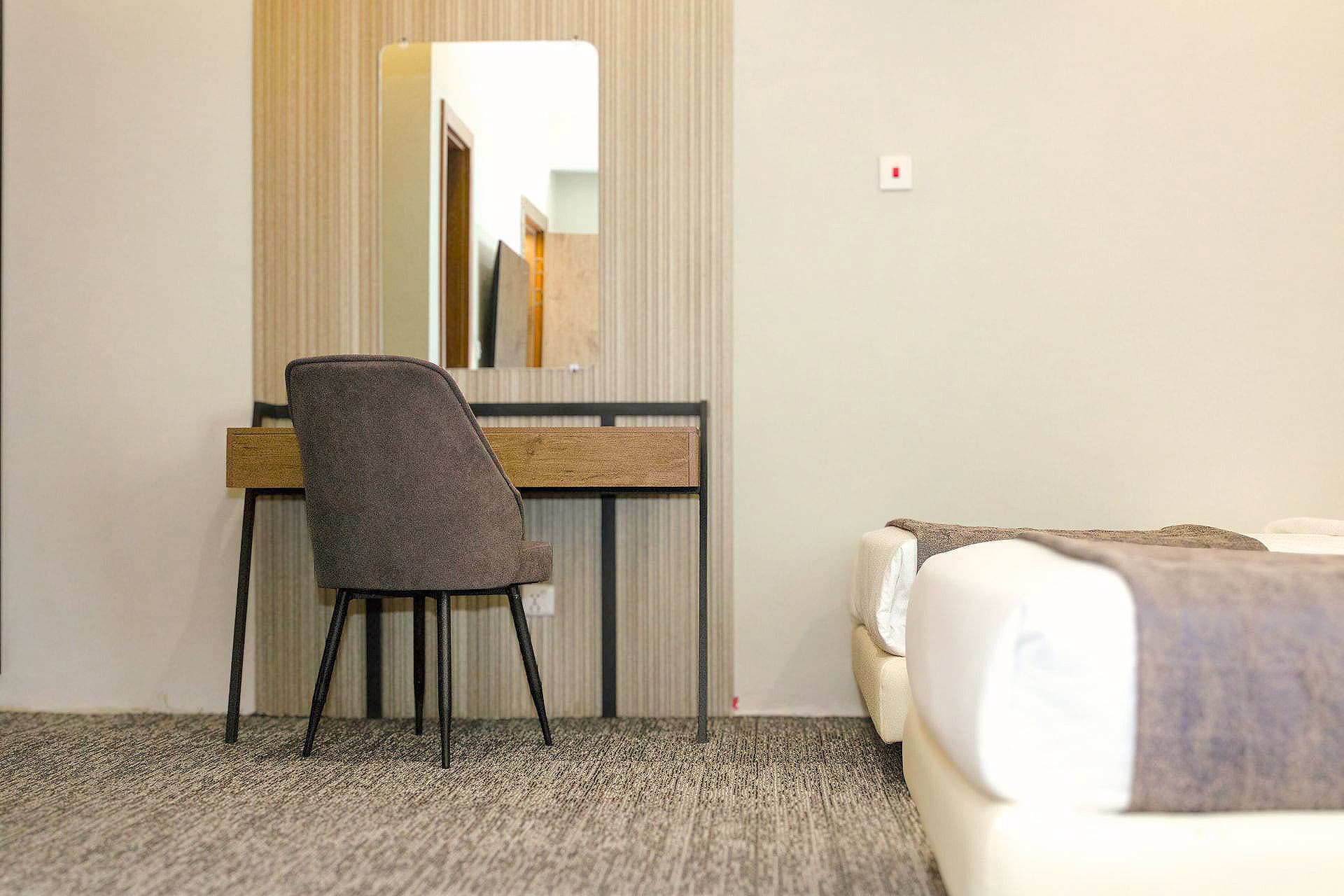 Twin Room semi-view with study table, AC, wall panels, bed, and carpet at LEORK Hotels Rawalpindi Islamabad