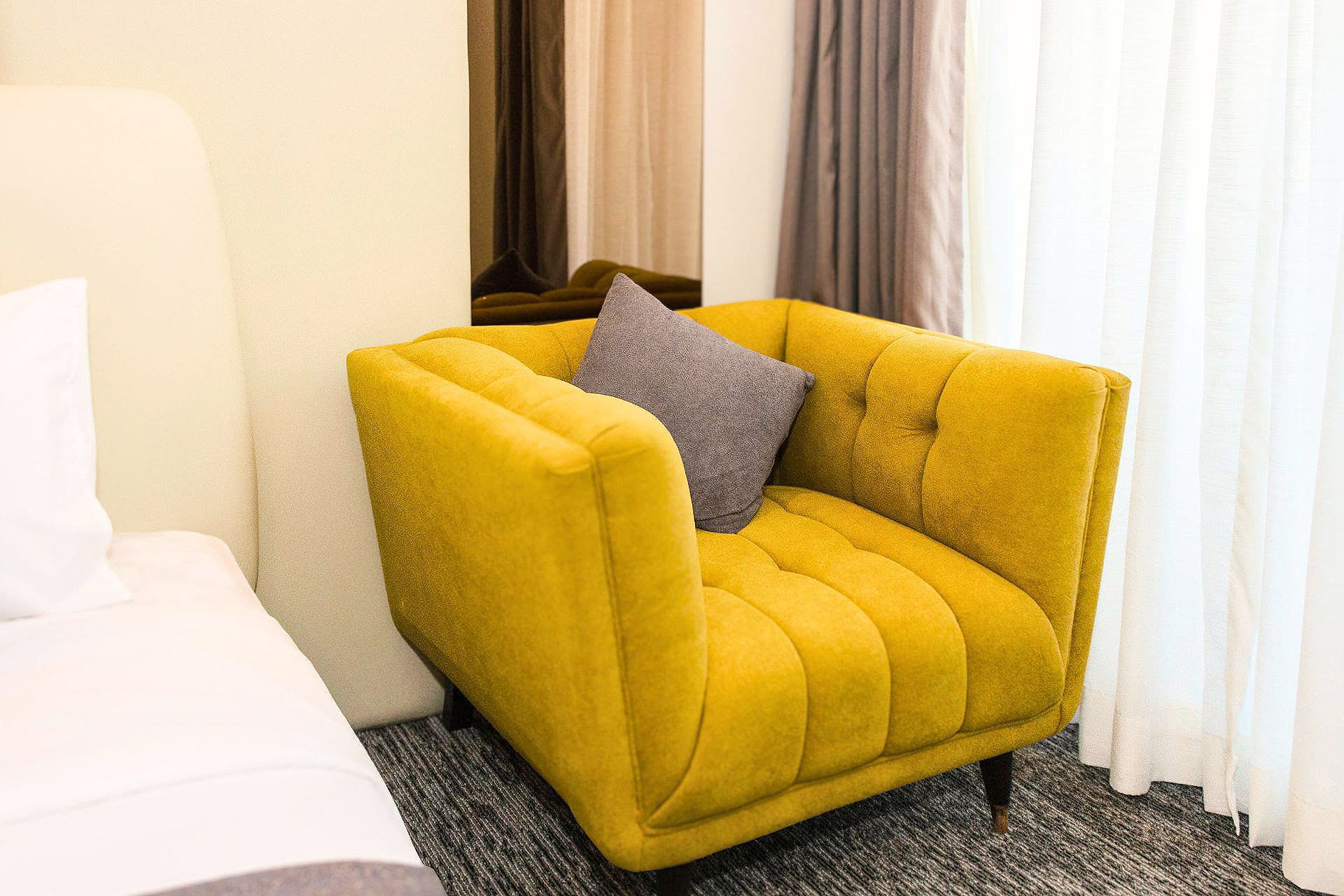 Twin Room close-up with modern sofa, mirror, window, and curtains at LEORK Hotels Rawalpindi Islamabad